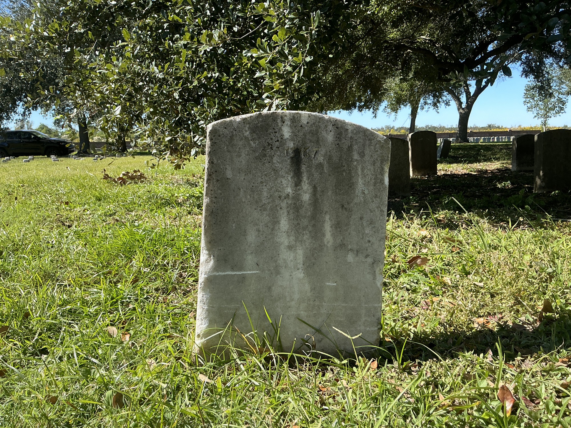Back of upright marble headstone with flat face.