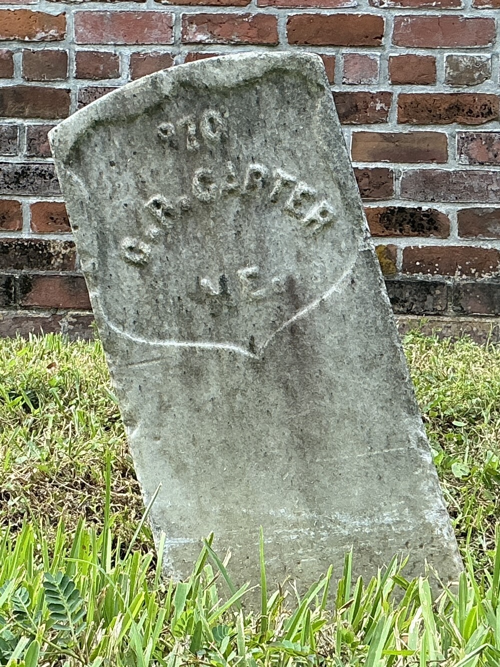 Front of historic upright marble headstone with recessed shield face.