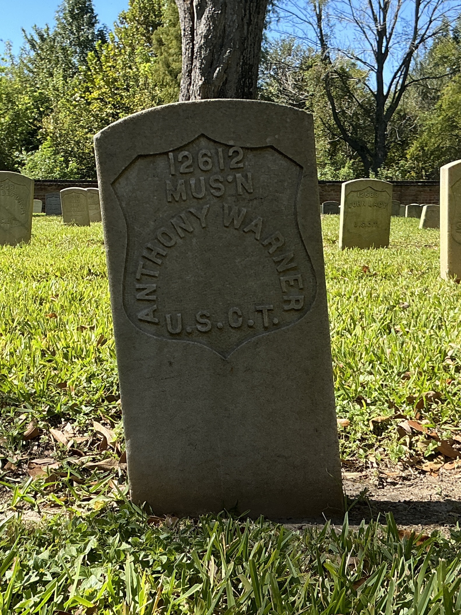 Front of historic upright marble headstone with recessed shield face.
