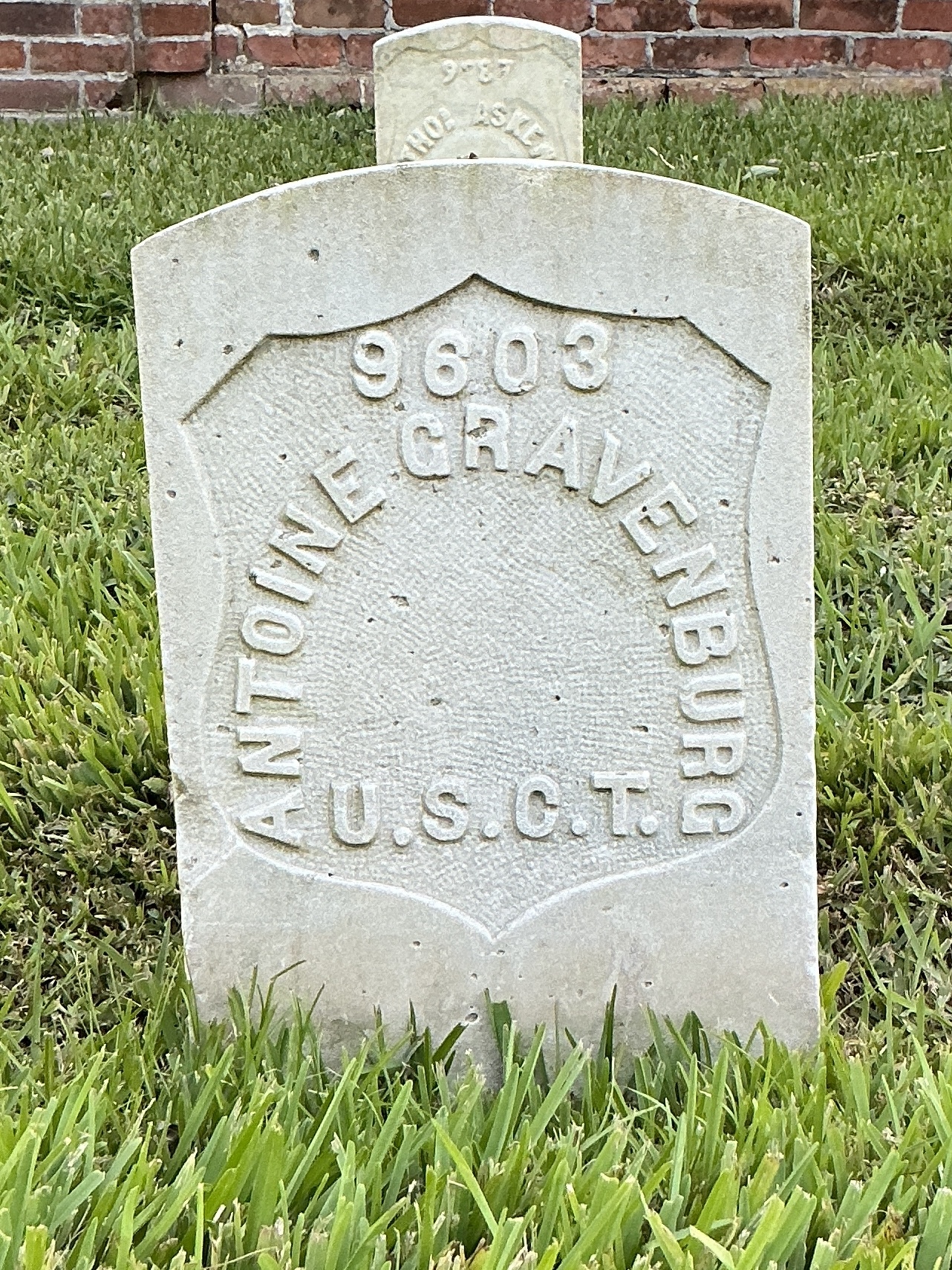 Front of historic upright marble headstone with recessed shield face.