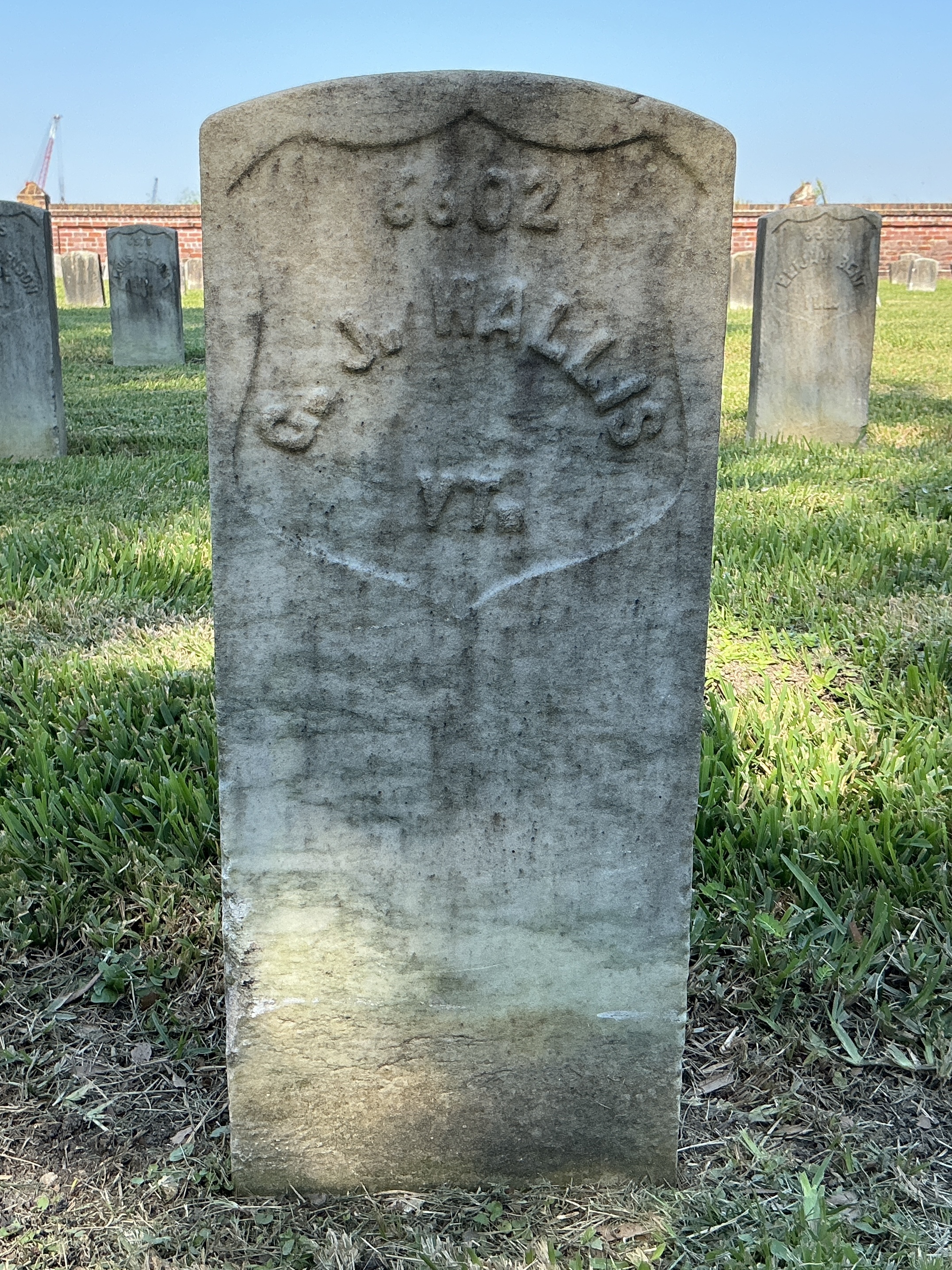 Front of historic upright marble headstone with recessed shield face.