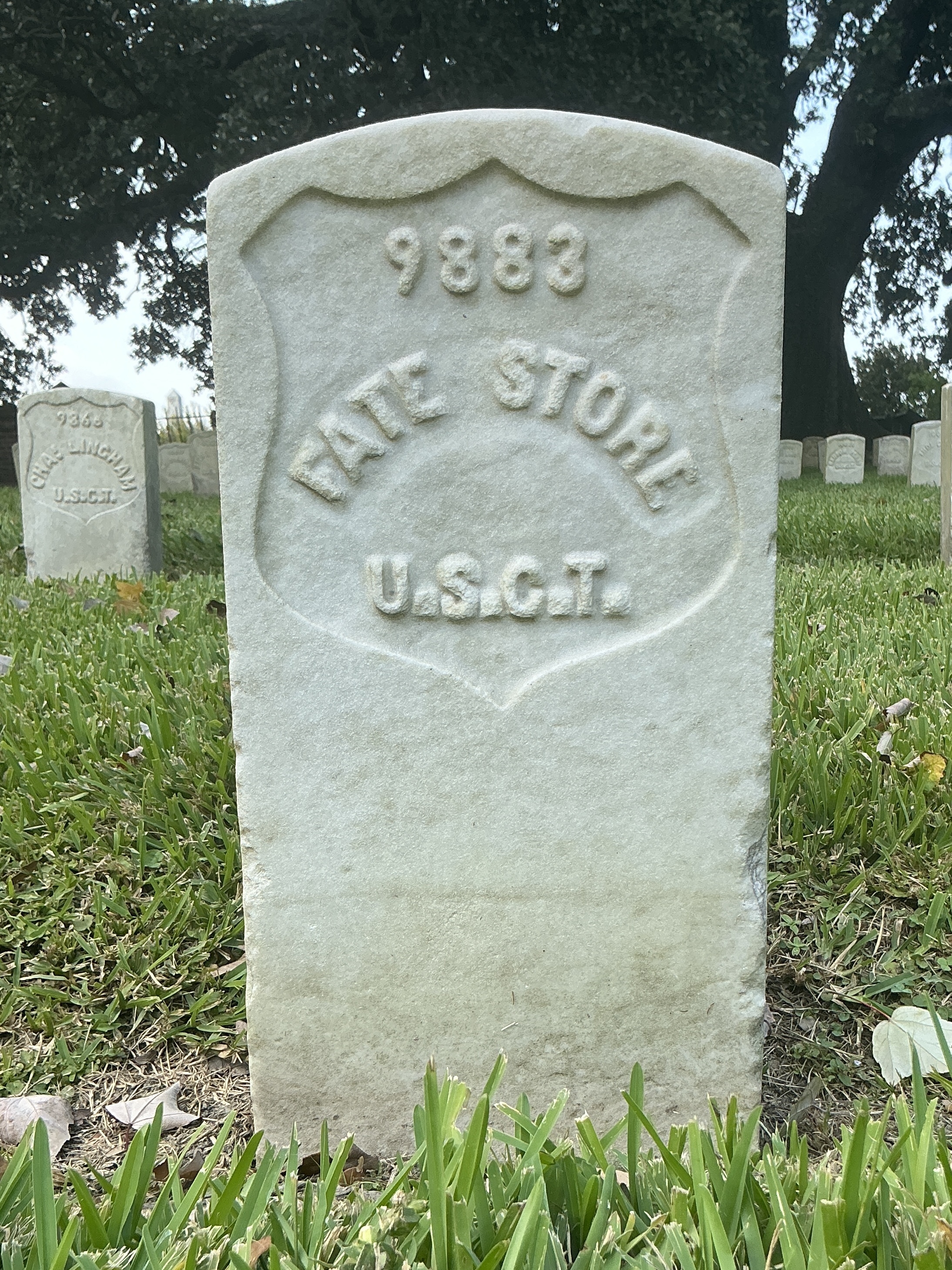 Front of historic upright marble headstone with recessed shield face.