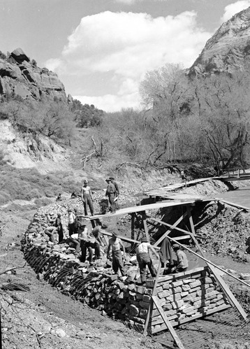 Zion Civilian Conservation Corps (CCC) workers constructing a stone basket dam at the NPS utility area.