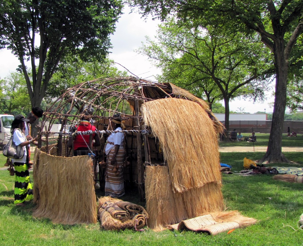 wood dome frame is having grass added, one quarter is almost to the top