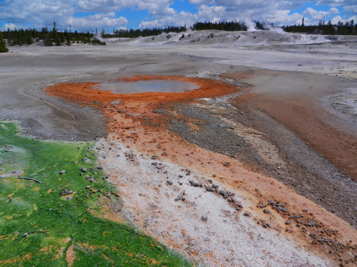 Bright orange runoff channel leads away from the round pool of water.