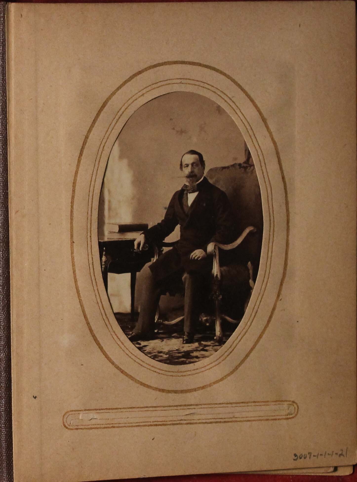 Black and white photograph of seated man at desk.