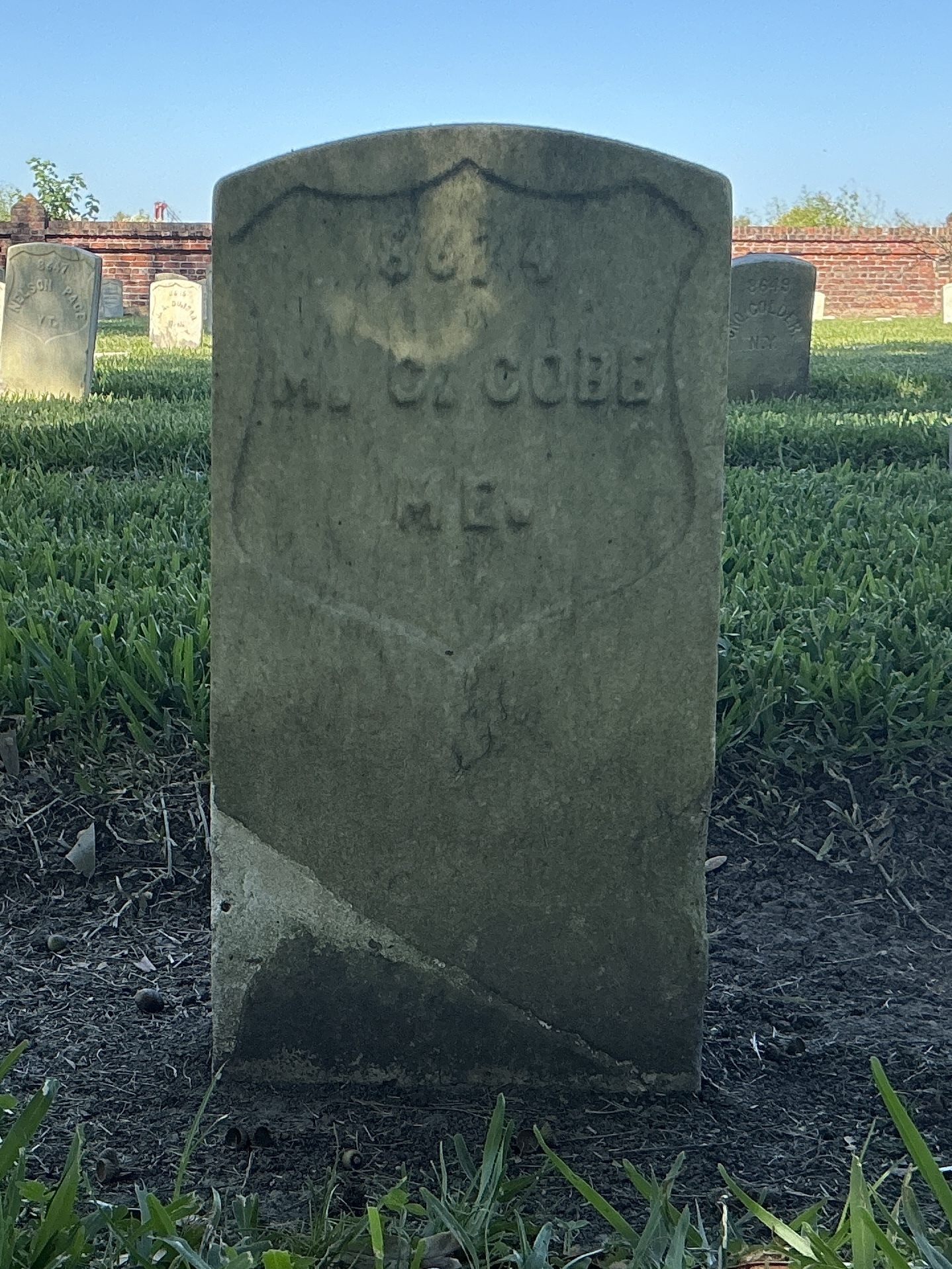 Front of historic upright marble headstone with recessed shield face.