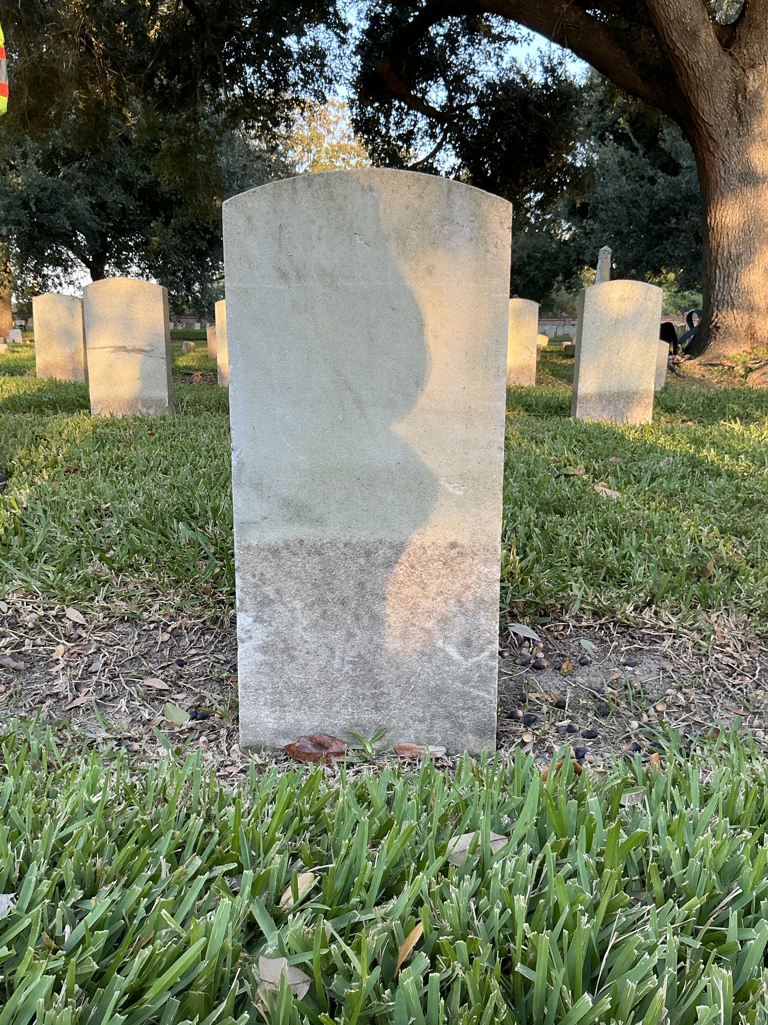 Back of historic upright marble headstone with recessed shield face.