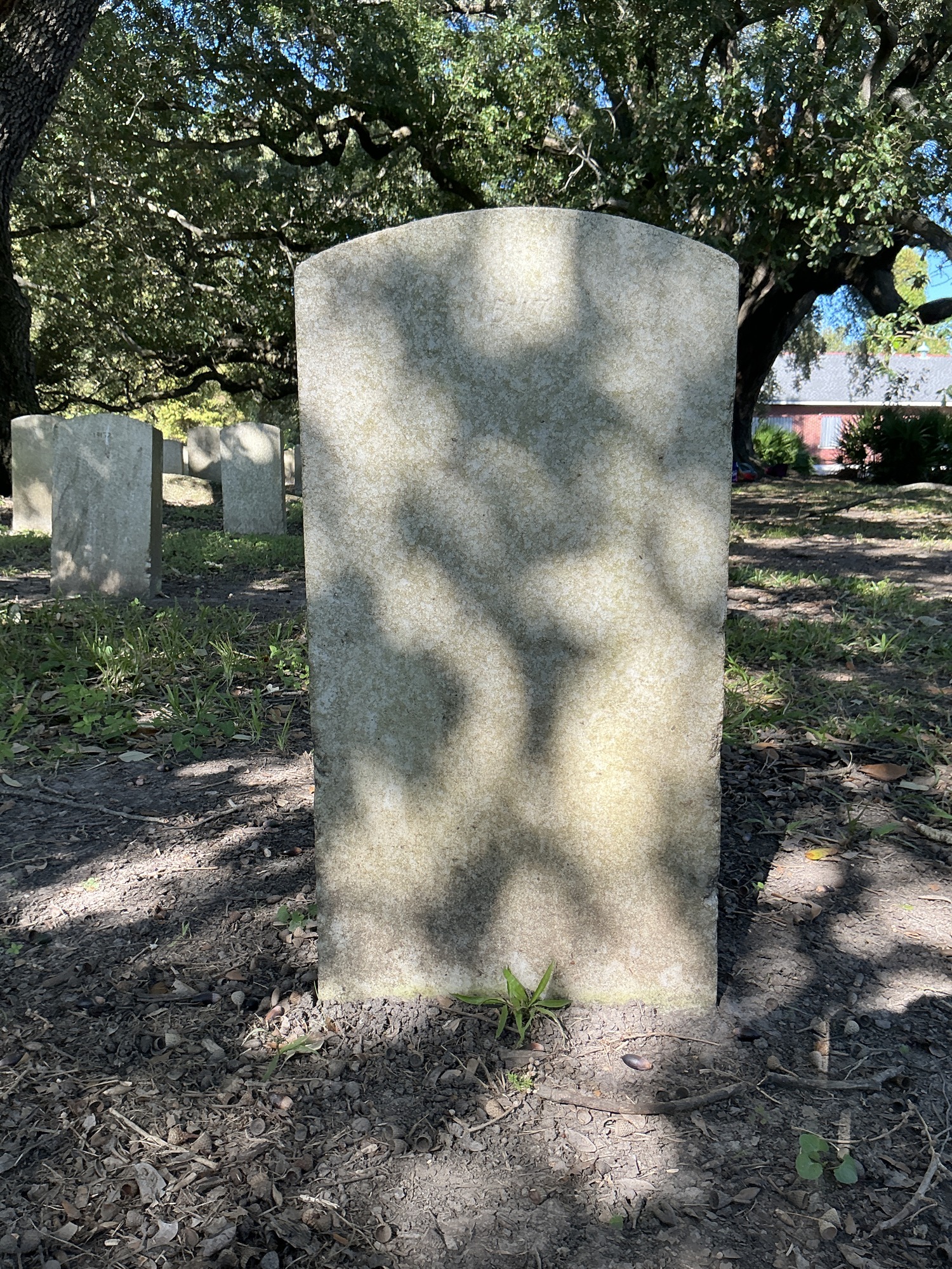 Back of upright marble headstone with flat face.