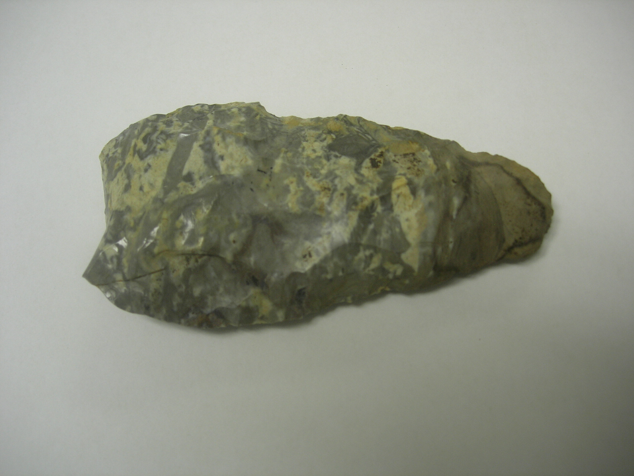 A roughly triangular-shaped stone showing chipping marks and a cutting edge.