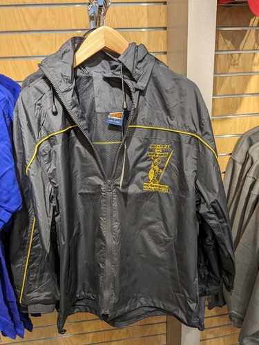 Dark blue rain jacket. Embroidered in yellow on the left side, a turtle wearing a helmet and a missile. Words "Bert the turtle says duck and cover. Minuteman Missile National Historic Site"