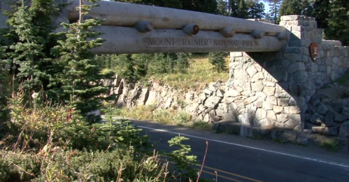 Large logs stretch across a roadway into stone abutments to form a walking bridge. 