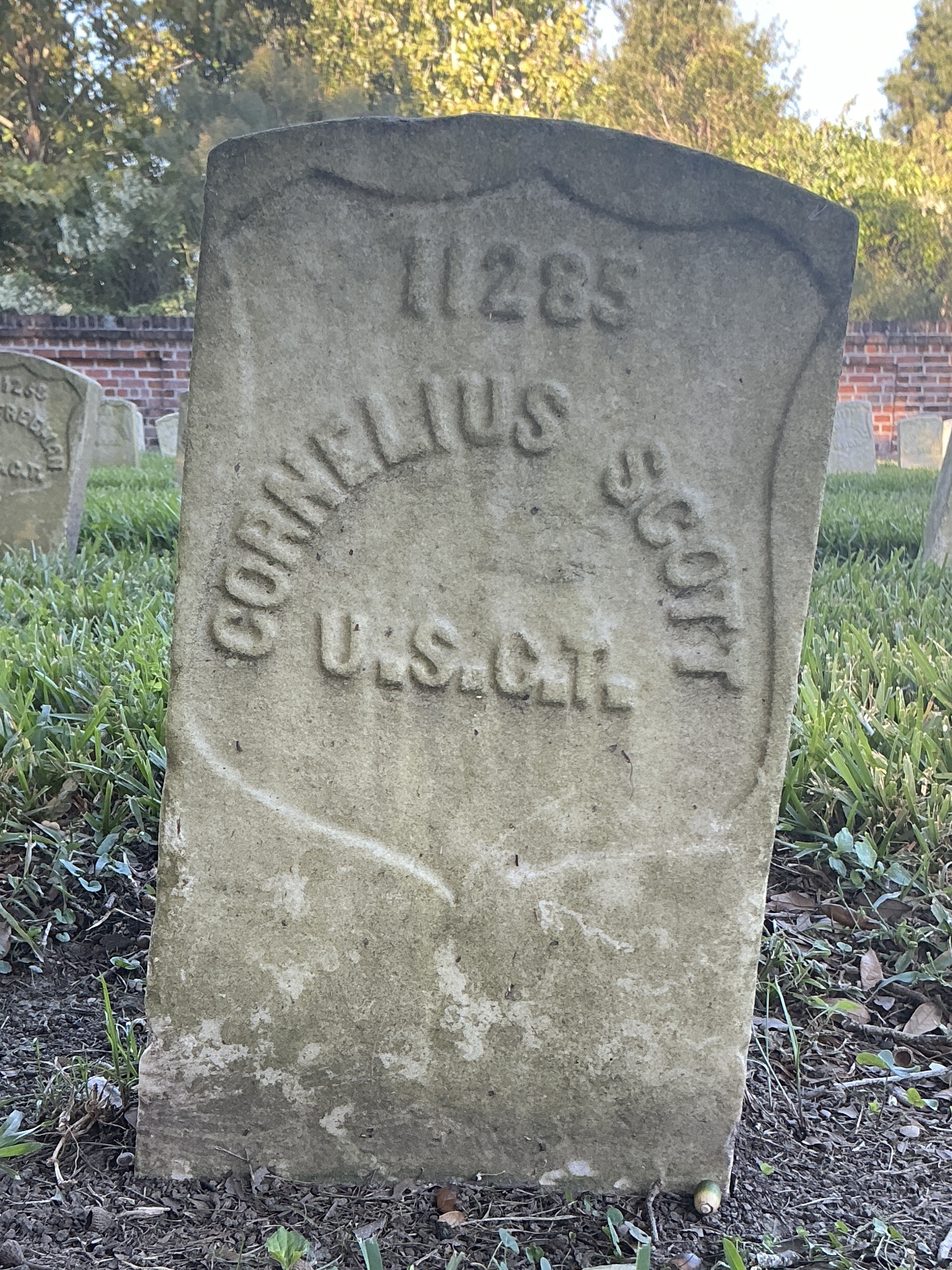 Front of historic upright marble headstone with recessed shield face.