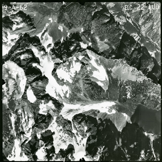 Black and white aerial photograph of glaciated mountain peaks and valleys.