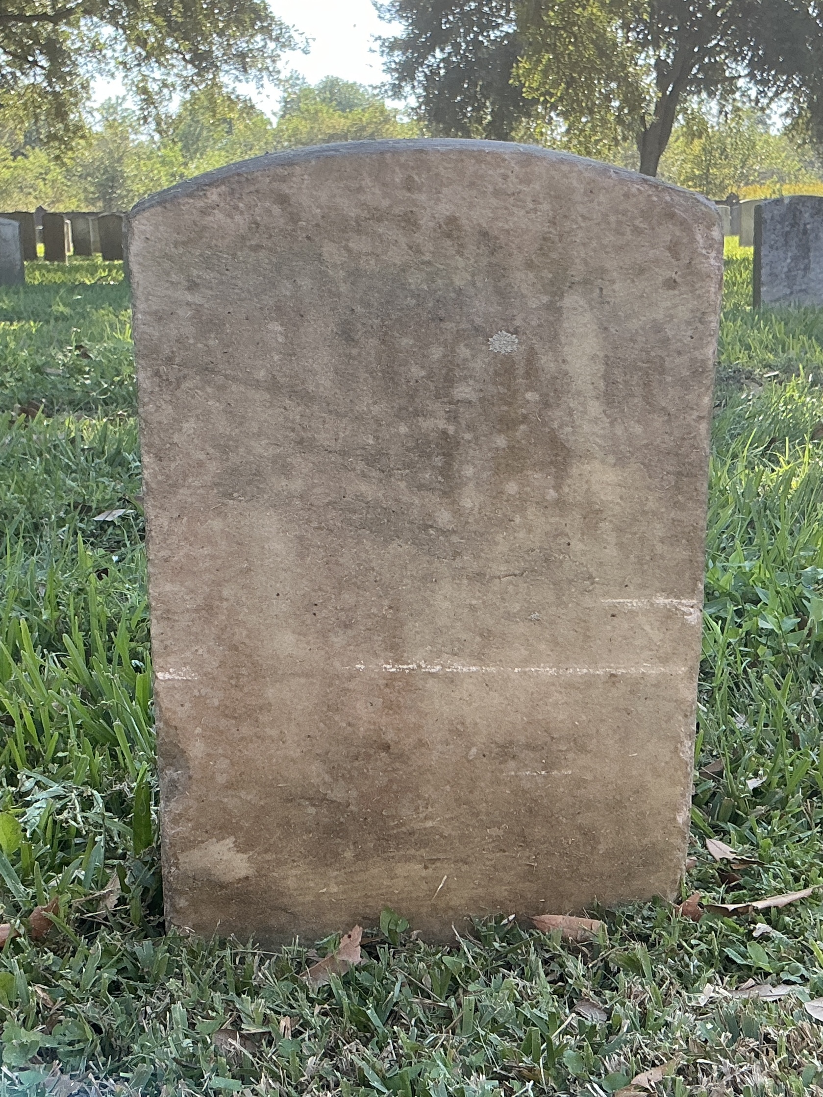 Back of historic upright marble headstone with recessed shield face.