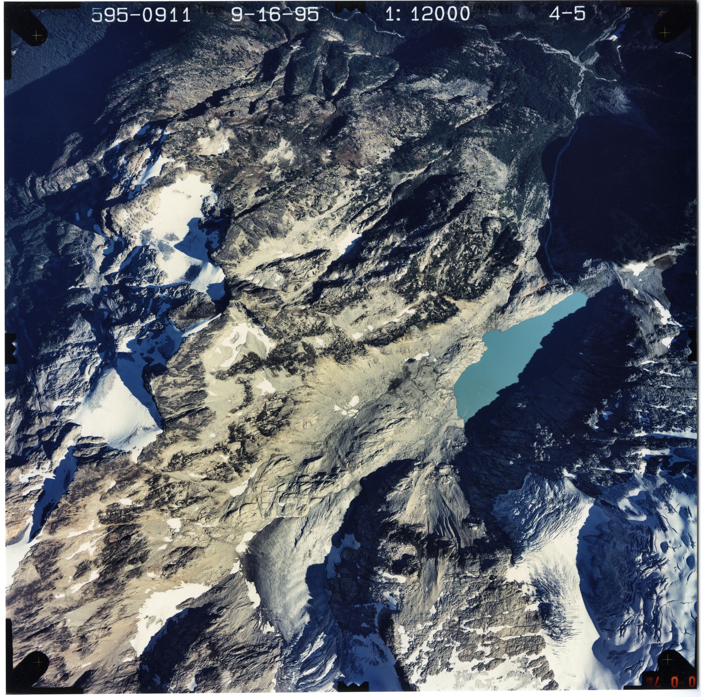 Color aerial photograph of glacier and snowfields on mountain peak.
