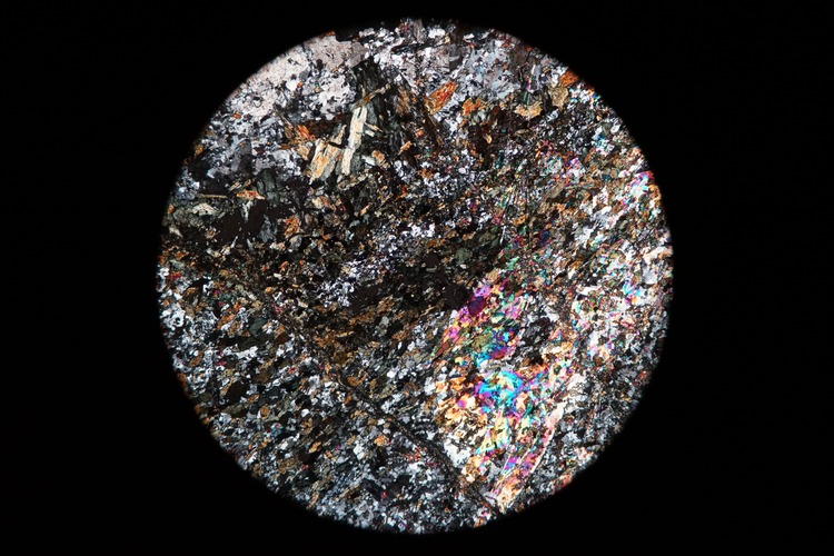 Circular microscopic image of rock structure.