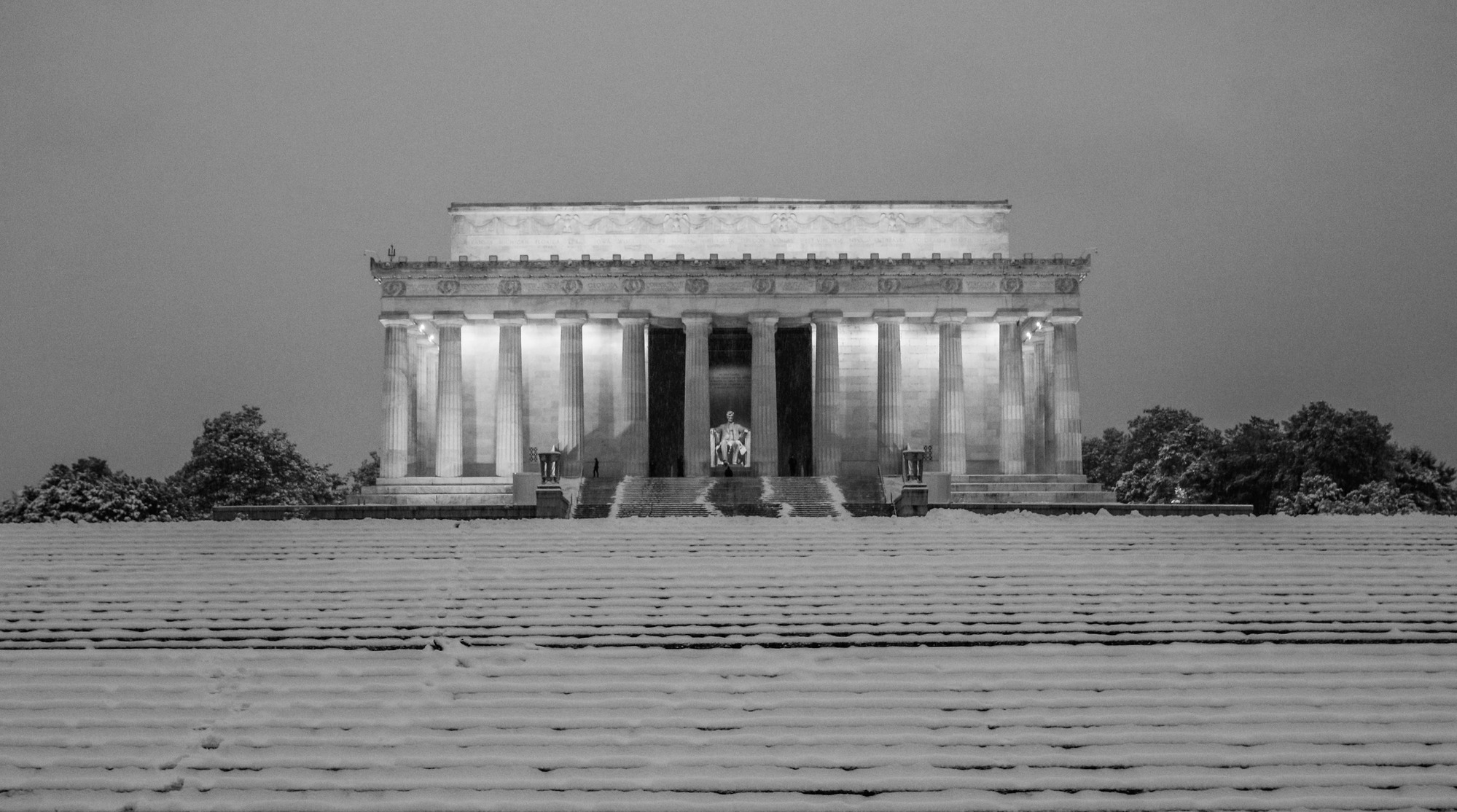 Black and white image of the Lincoln Memorial covered in snow before dawn