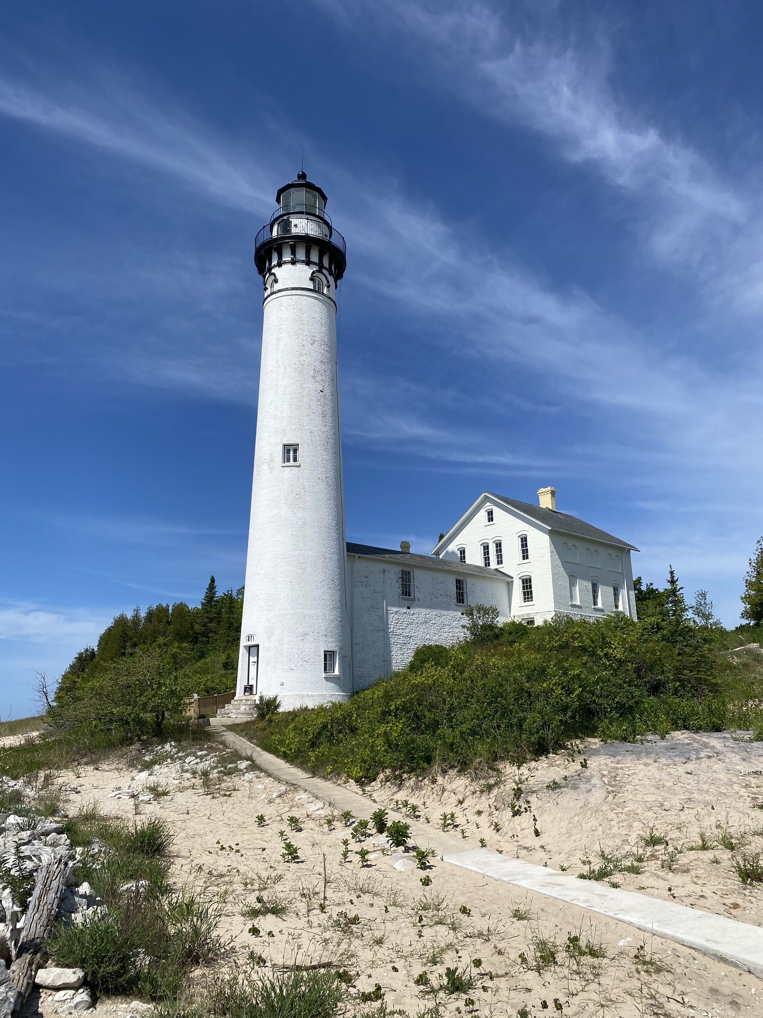 A picturesque lighthouse stands at the edge of the South Manitou Island.  It's a nostalgic reminder of the successful triumphs of survival of prior generations. 