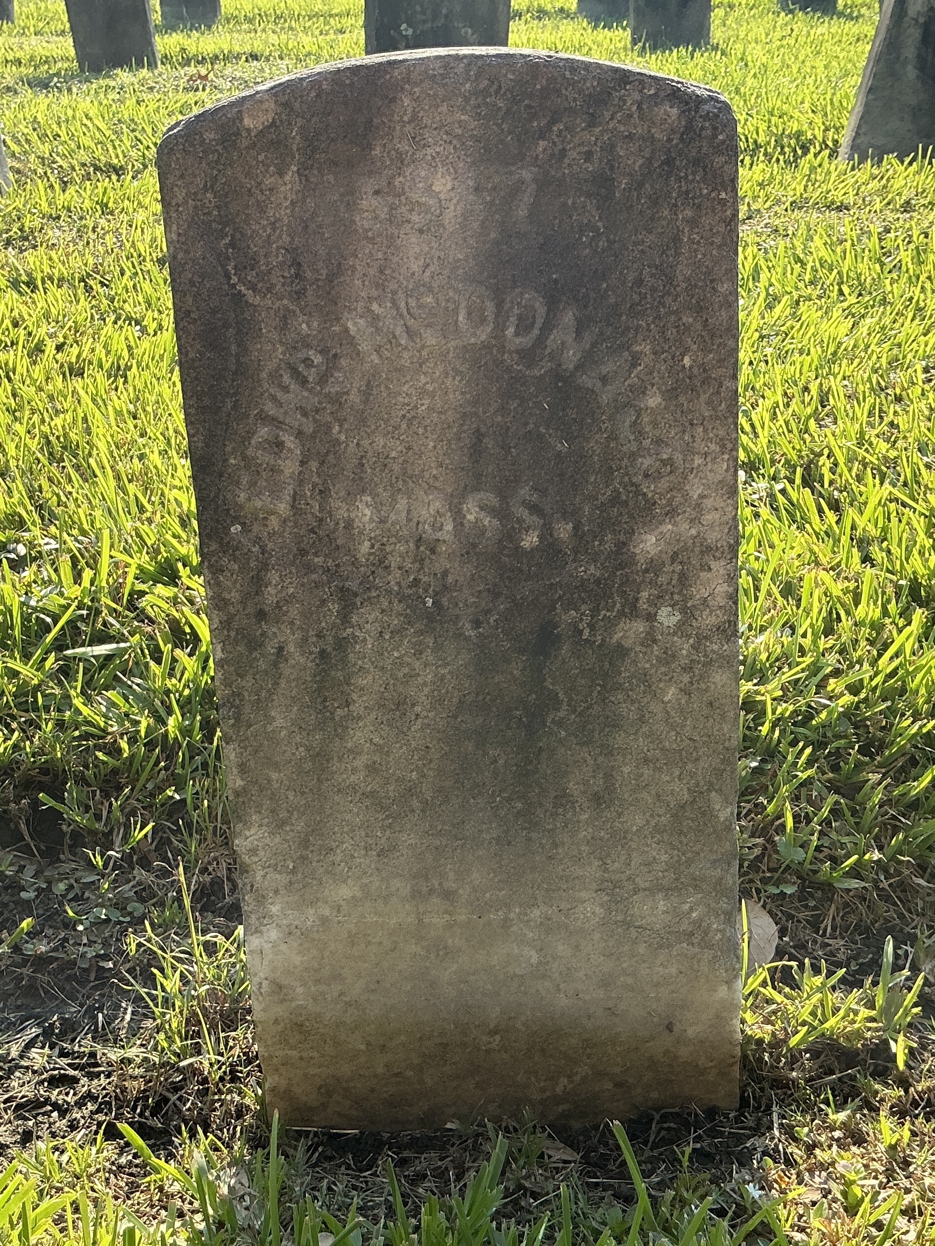 Front of historic upright marble headstone with recessed shield face.