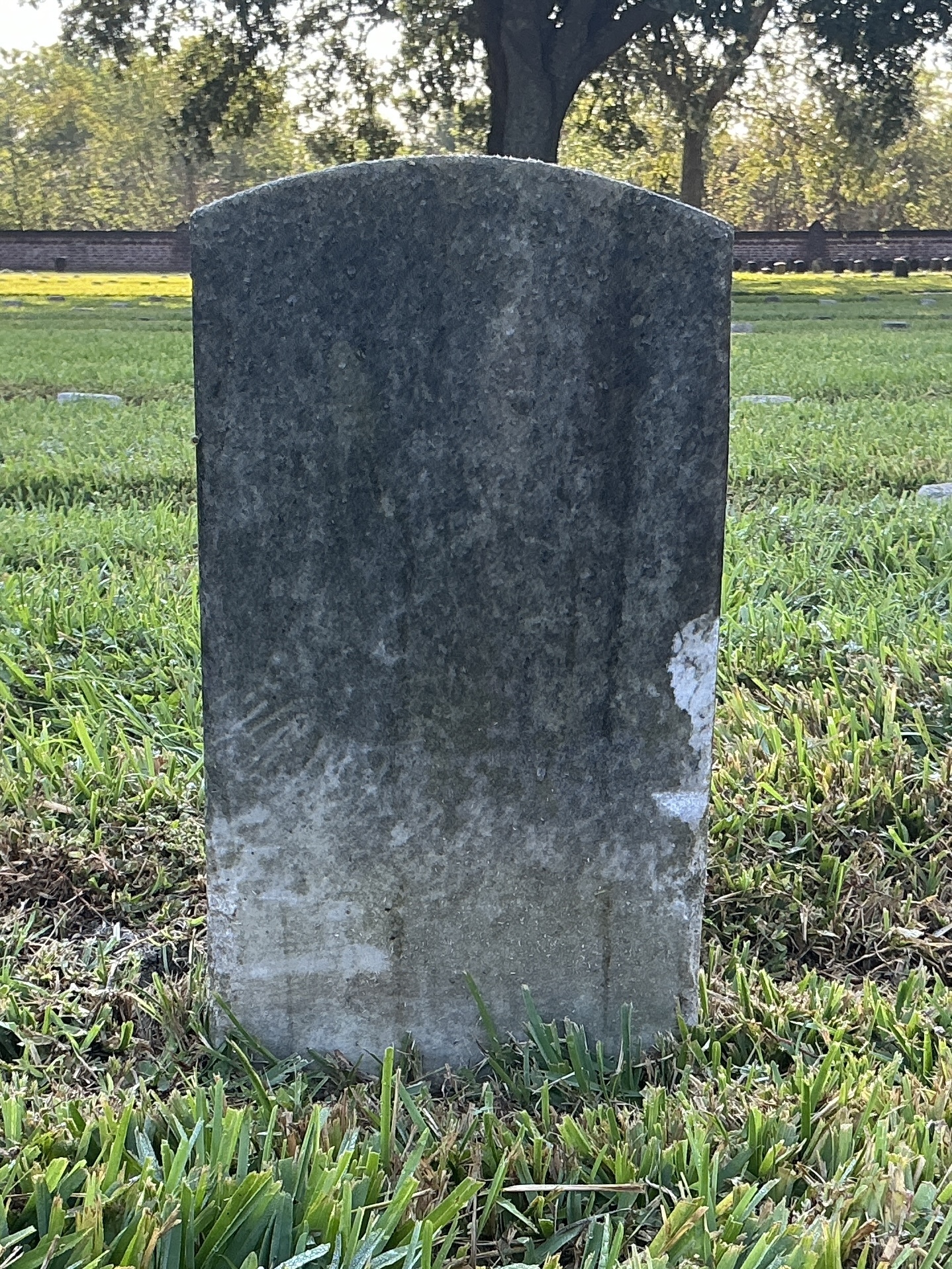 Back of historic upright marble headstone with recessed shield face.