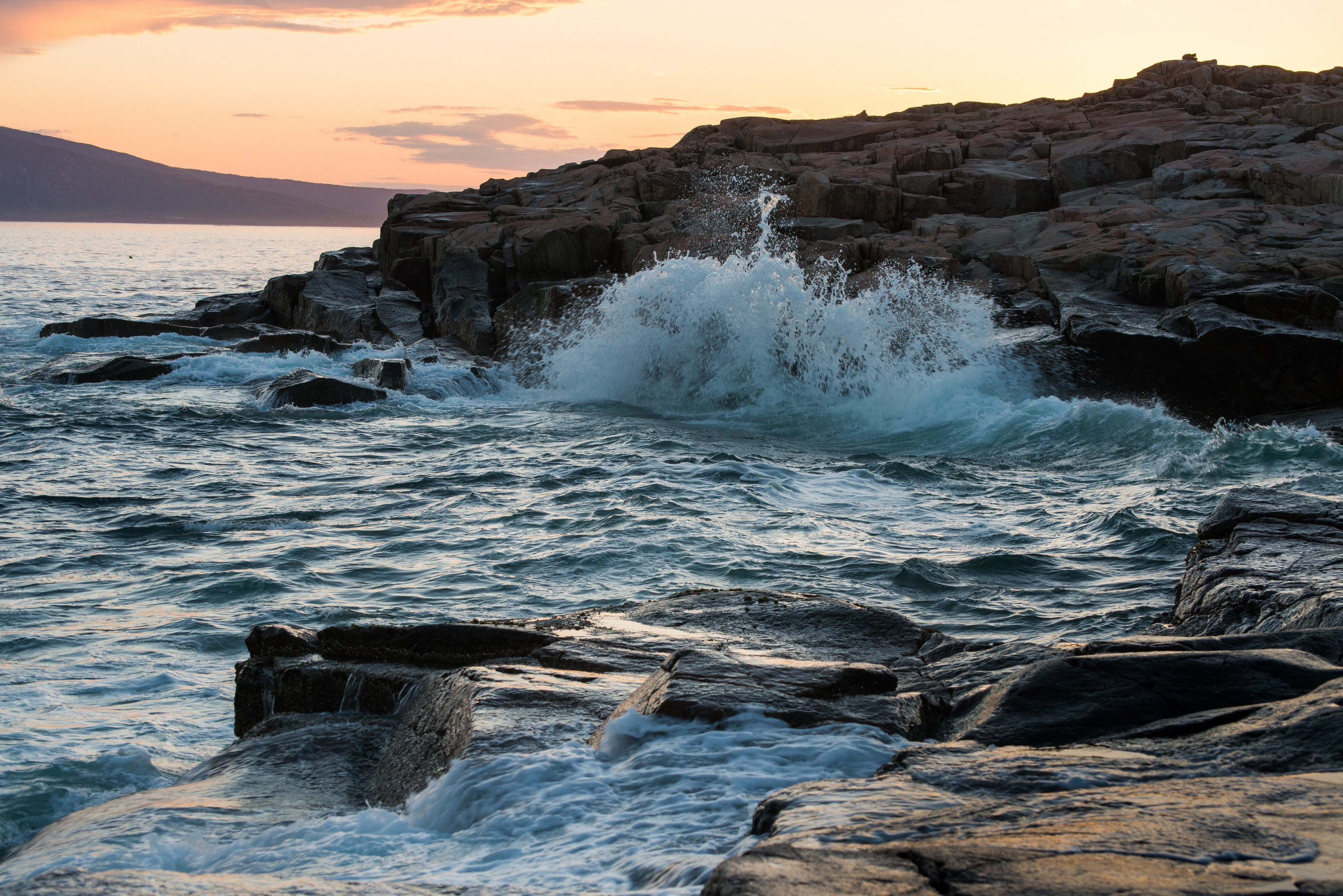Waves crashing on a rocky coastline at sunset