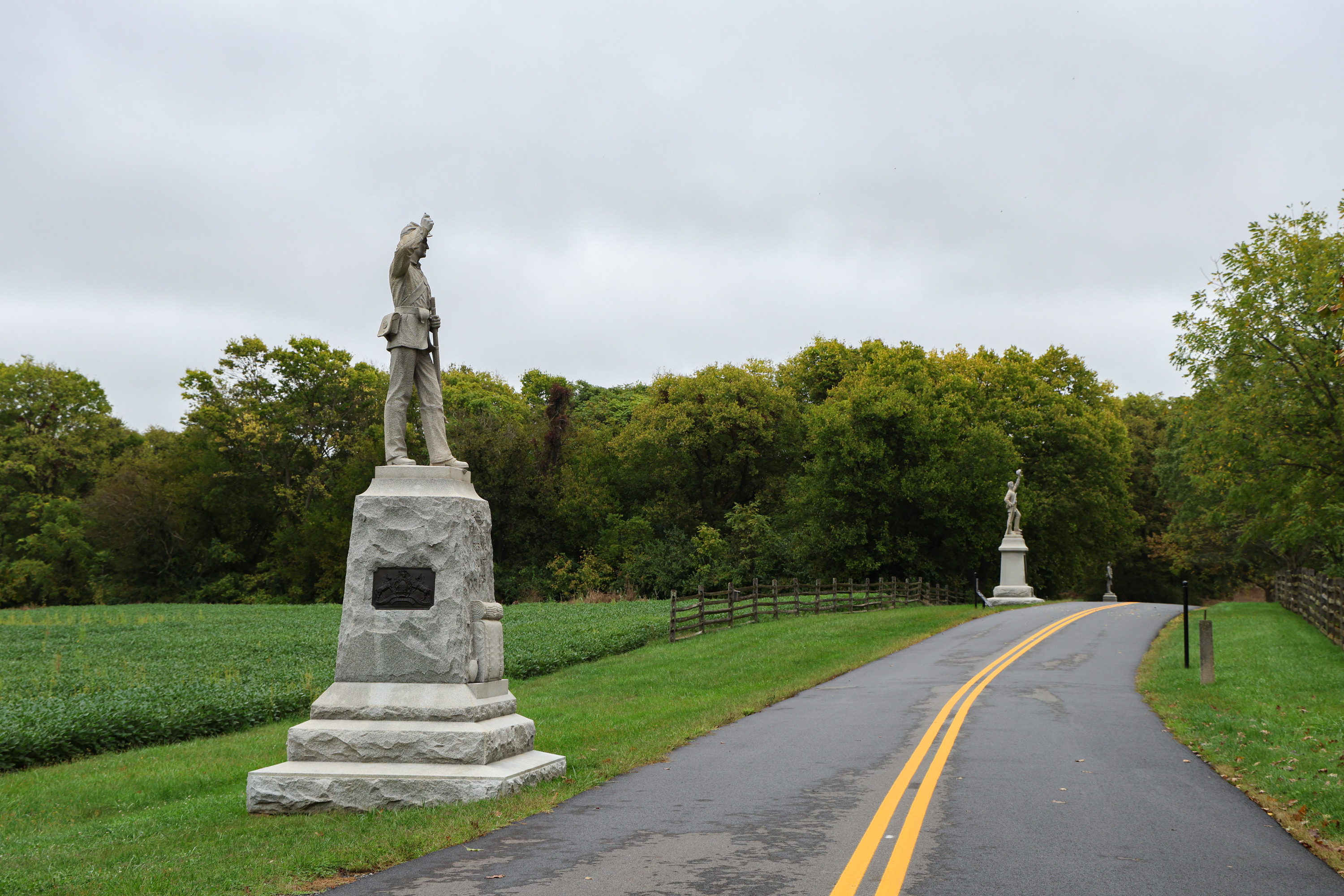 A road with two memorials on the left hand side. 