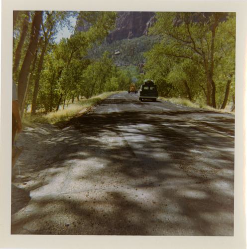 Cars driving down road with shoulder along route 2 parking areas.