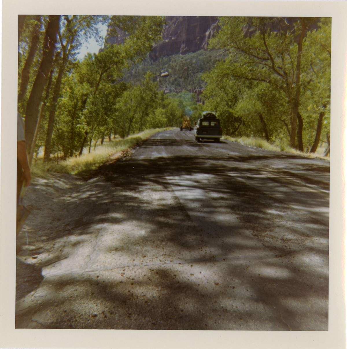 Cars driving down road with shoulder along route 2 parking areas.