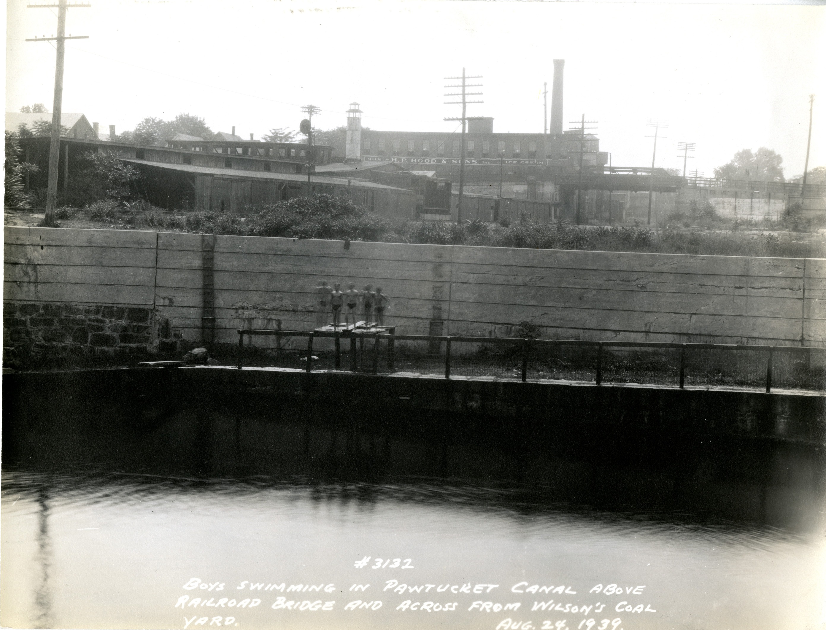 A photo showing boys on a jumping platform over the canal.