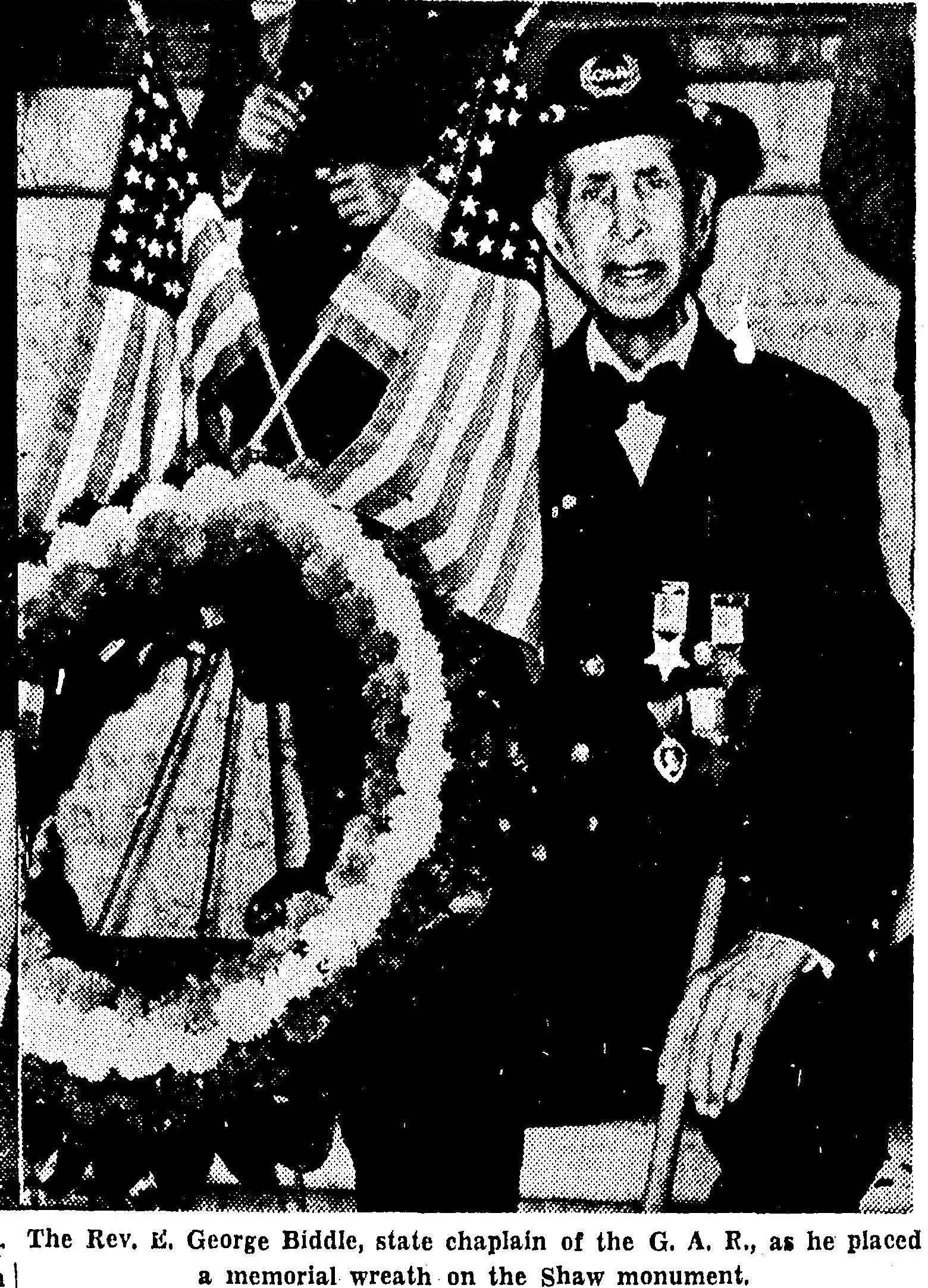 Veteran sitting in front of the 54th Regiment Memorial with a wreath. 