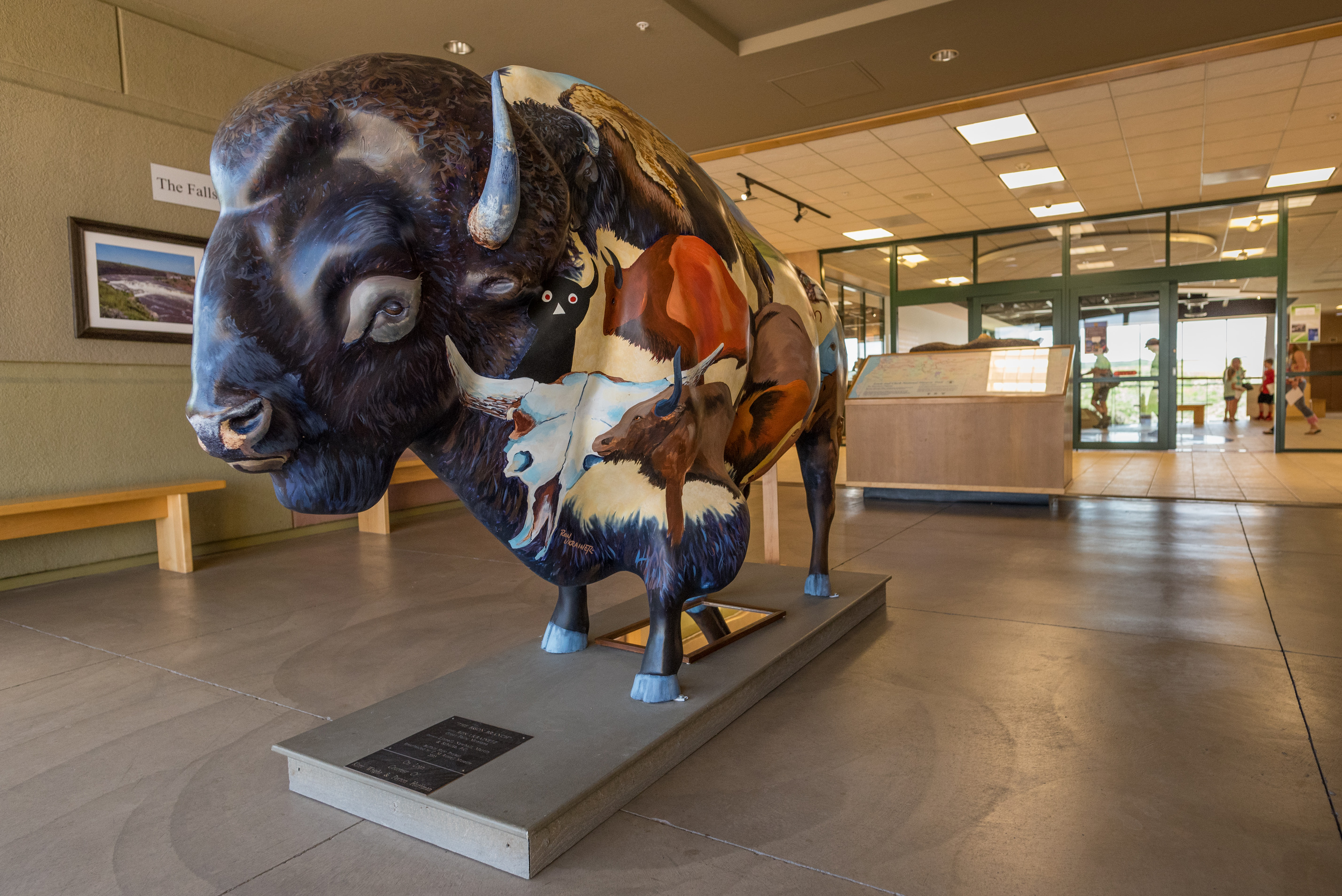 Bison sculpture painted with indigenous designs and paintings of bison