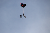 two base jumpers, one with chute partially deployed