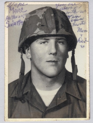Wallet photograph of Marc Anthony Sivatta (KIA 06/20/1966). Photograph was taken in studio and depicts LCpl Sivatta wearing uniform and M1 helmet, his face and upper chest visible. Written around his image are his name a the message "You are always with us in our hearts. Mom + Dad xx".