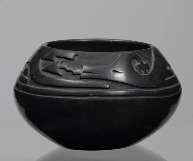 Round black pot with engraving on the top half 