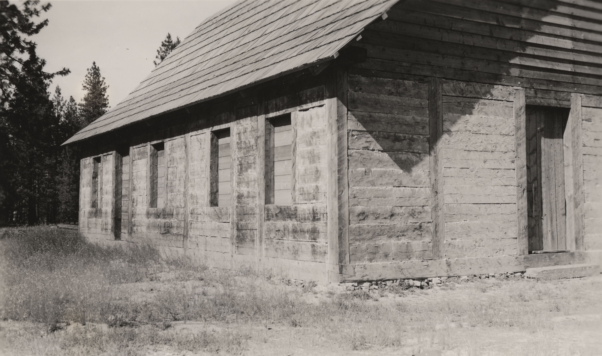 Black and white photograph of a part of a plain wooden building