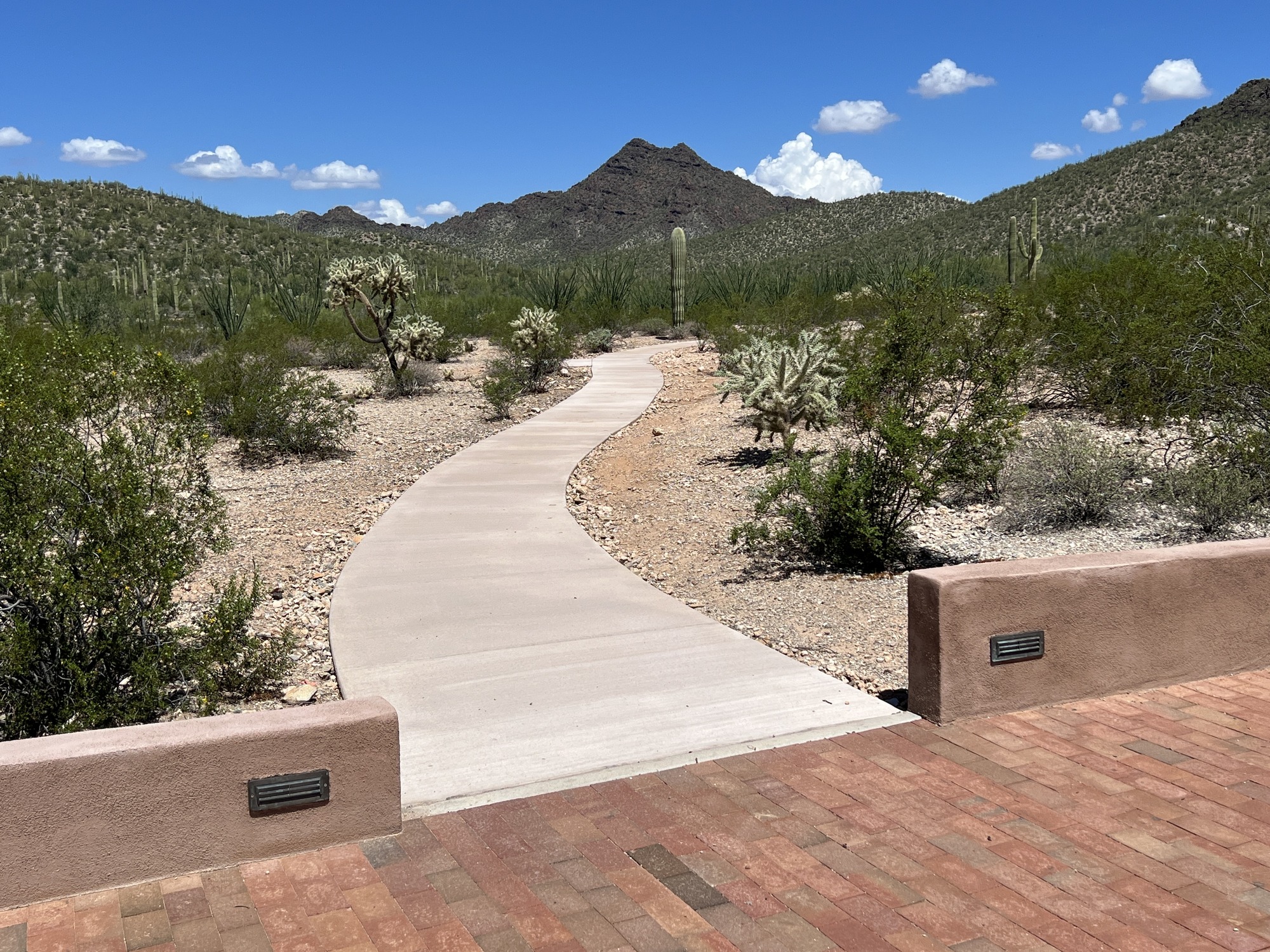 A level brick pavement going to the amphitheater joins with a concrete pavement that encircles the eastern side of the campground.