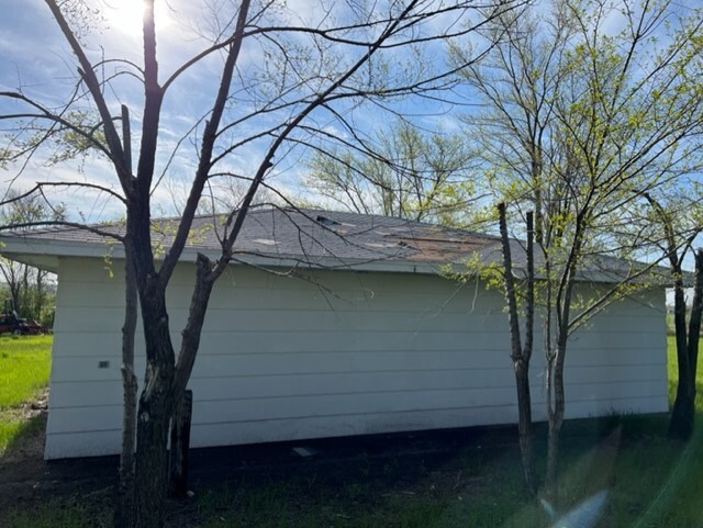 Building from behind, with trees in front of it.