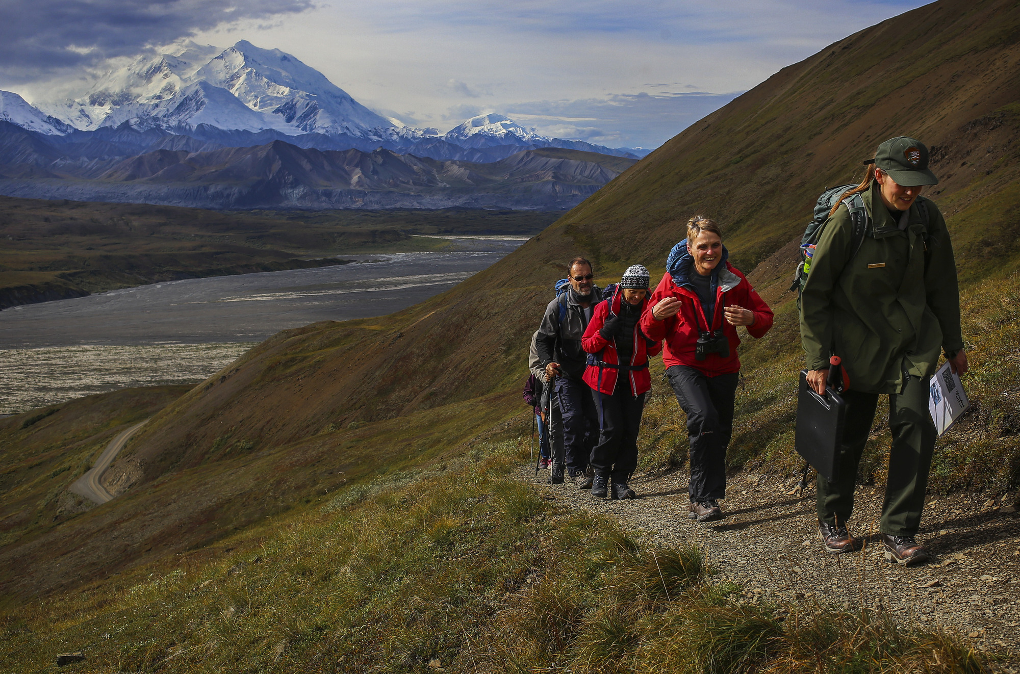 a ranger leads hikers up a mountainside trail