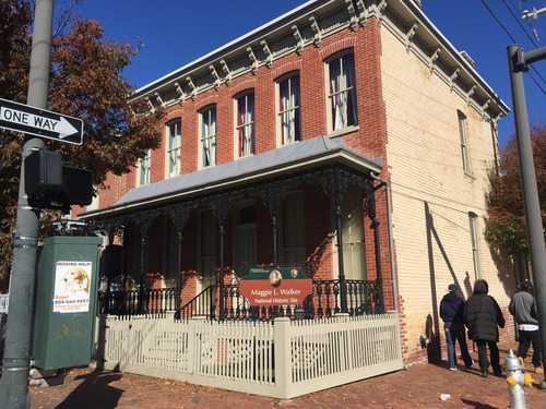 Two-story brick house with a porch and fence 