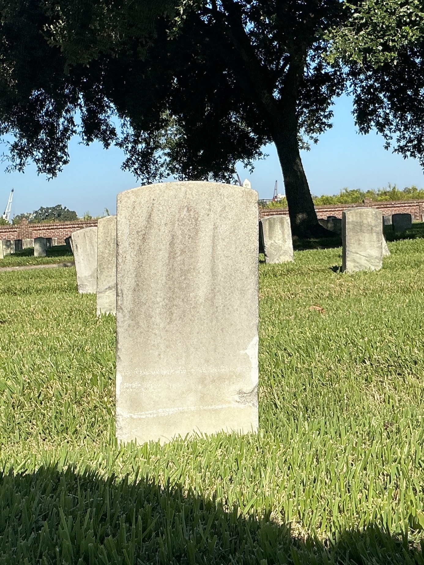Back of historic upright marble headstone with recessed shield face.