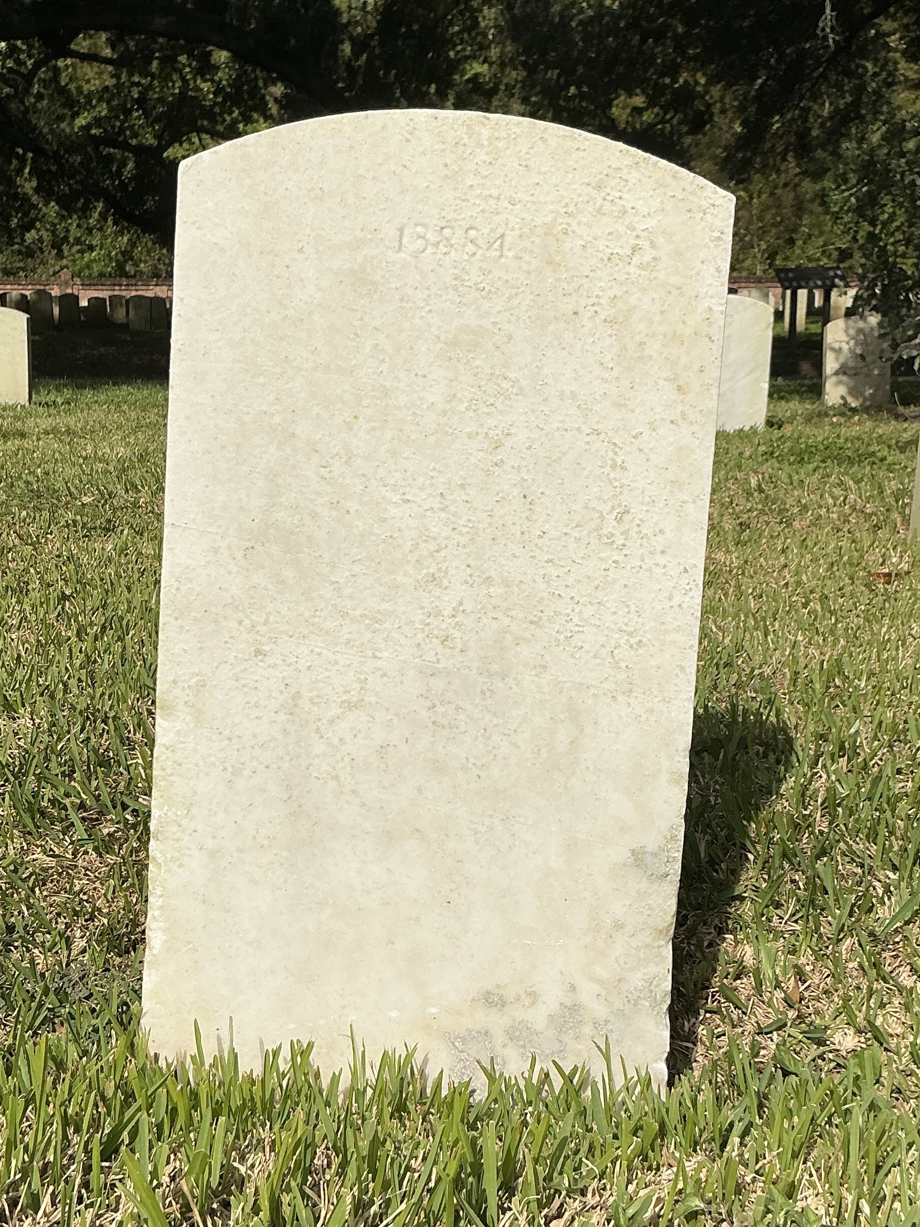 Back of upright marble headstone with flat face.