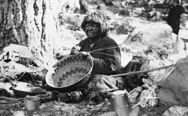 Kolopine, old Yosemite Native American woman, working on a basket.