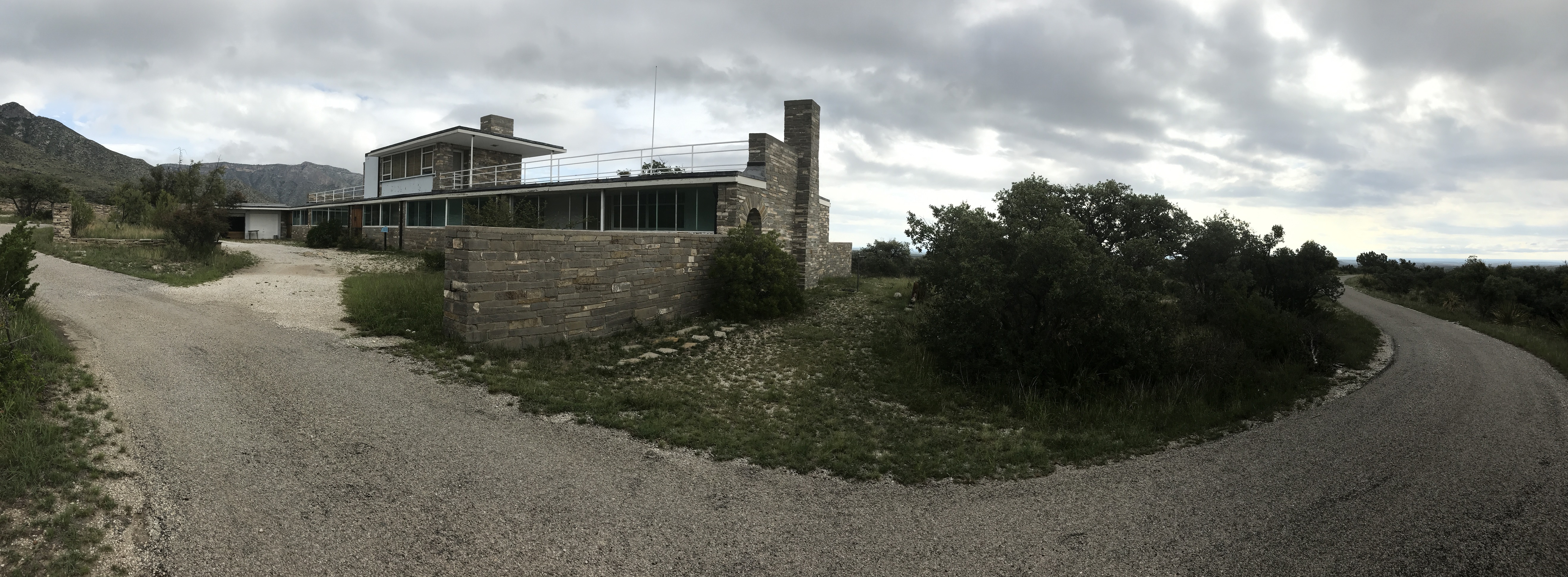 A rectangular house in a desert mountain landscape.