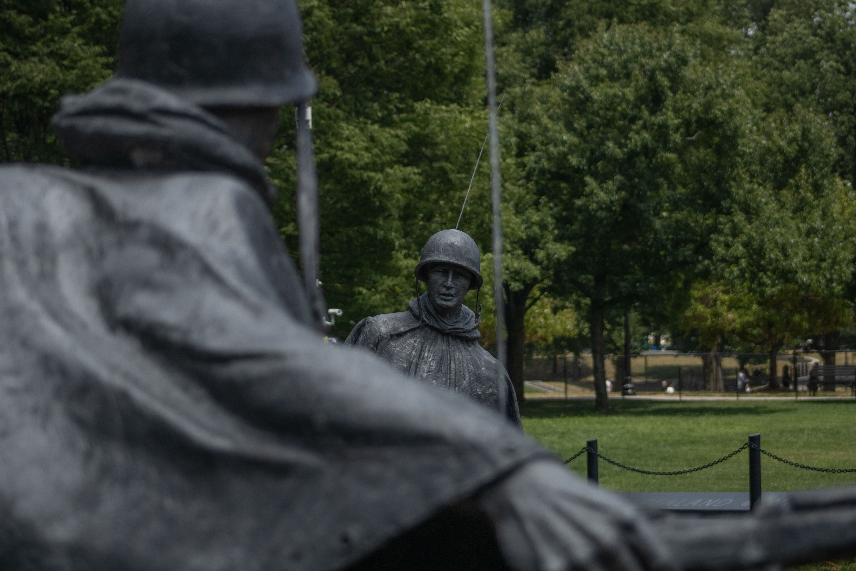 A statue of a Korean War soldier emerges from behind the shoulder of another statue of a soldier at the Korean War Veterans Memorial. 
