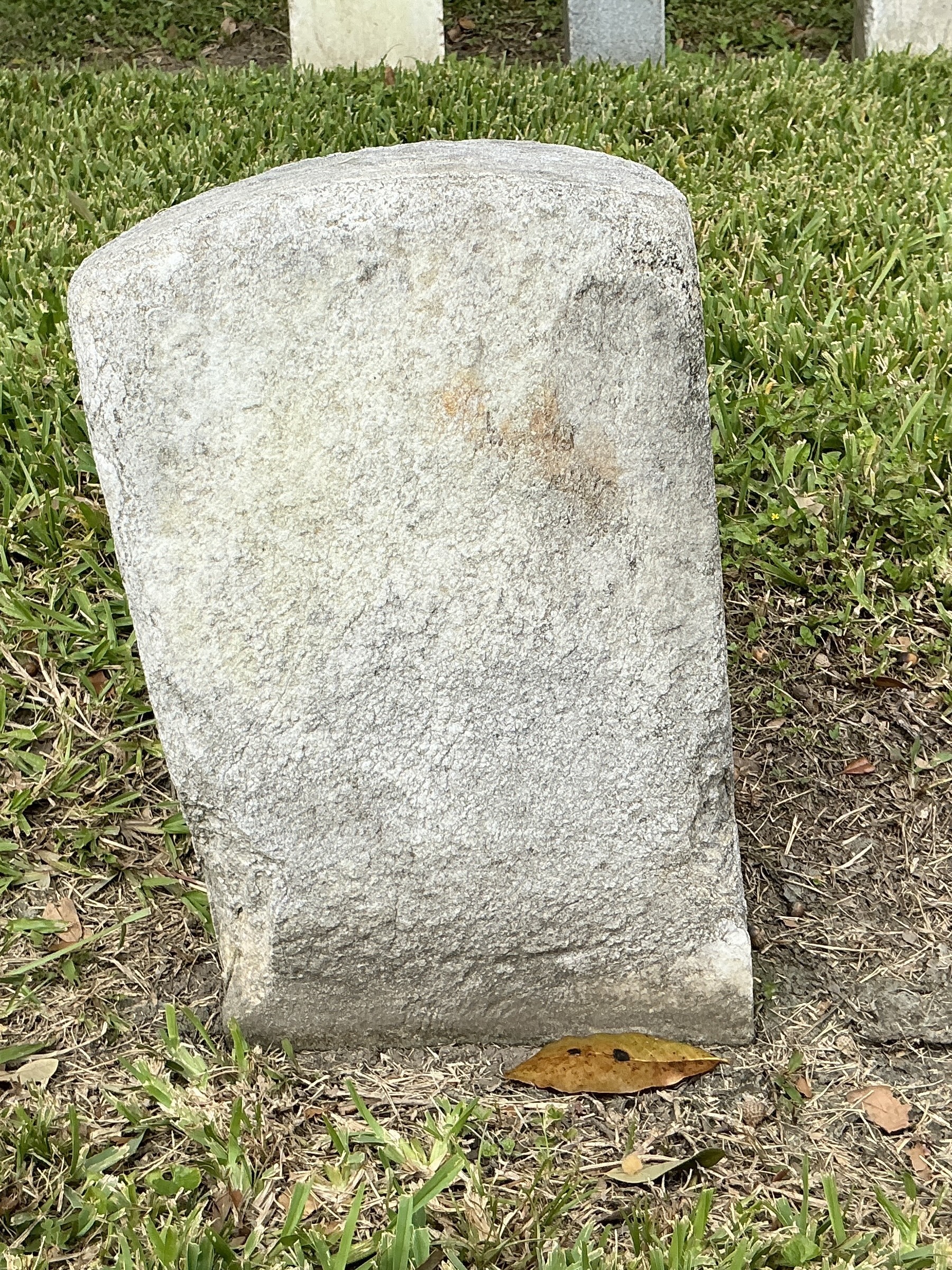 Back of historic upright marble headstone with flat face.