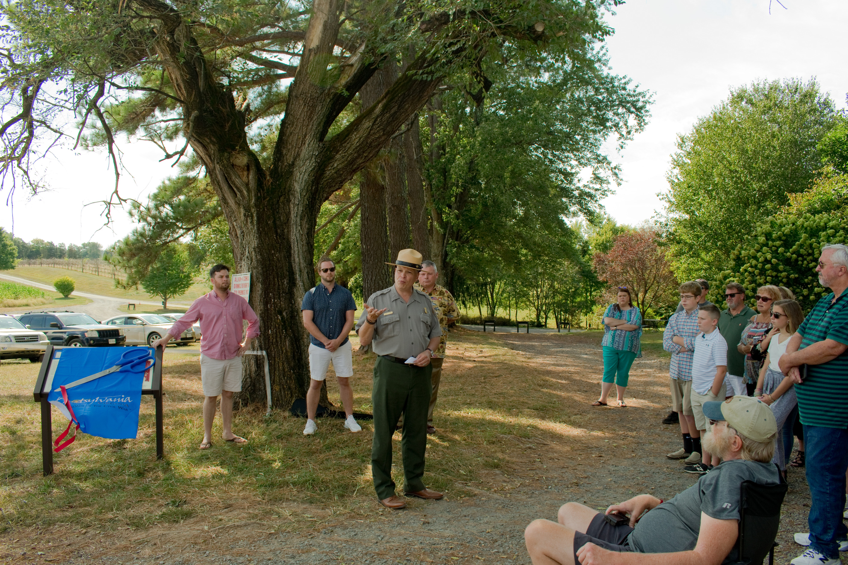 A Park Ranger talking in front of a shrouded wayside.