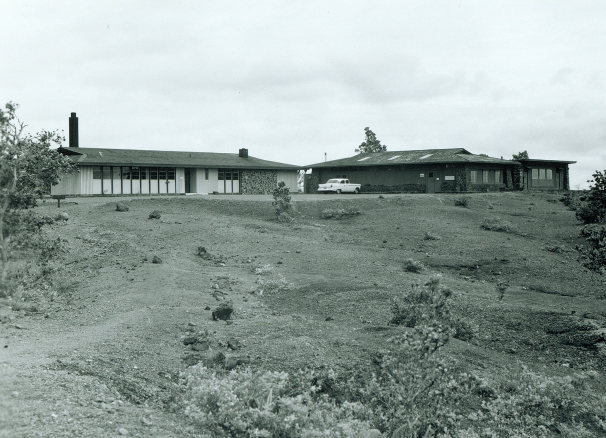 Black and white image of three buildings viewed from a distance. 