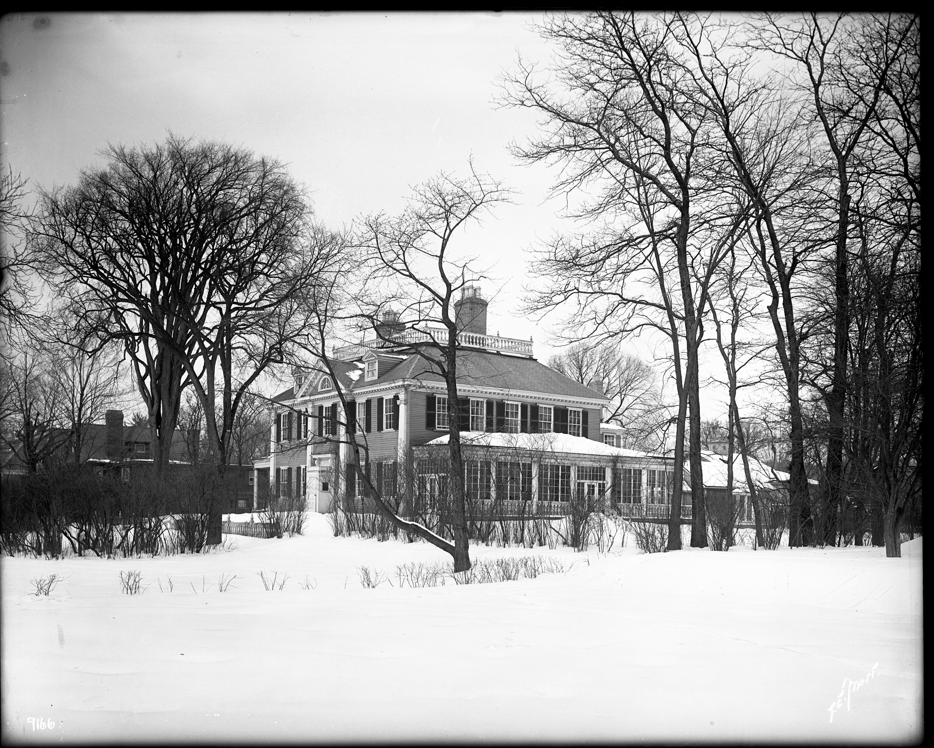 Black and white photograph of Georgian mansion in the snow.