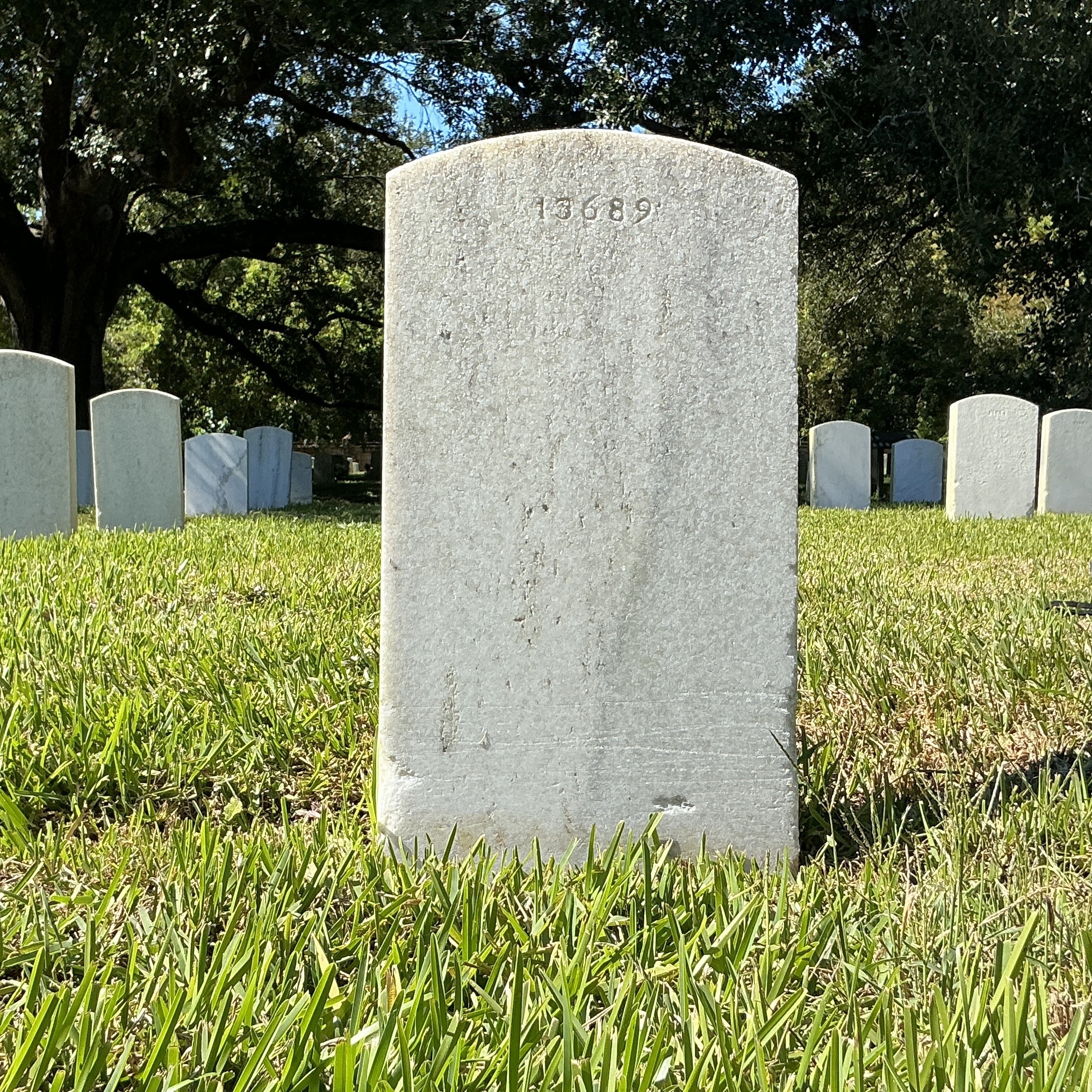 Back of upright marble headstone with flat face.